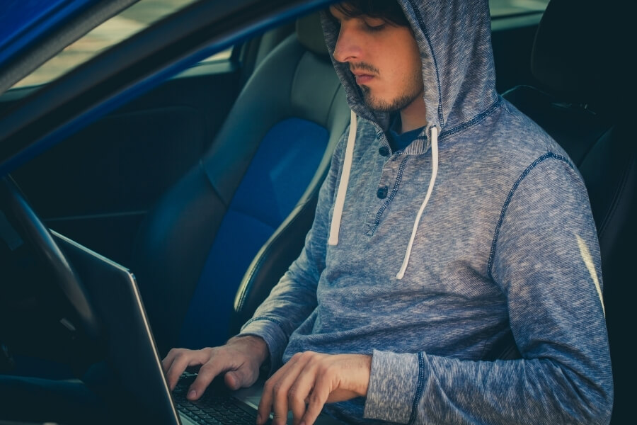 wardriving hacker trying to get information working on a laptop in their car