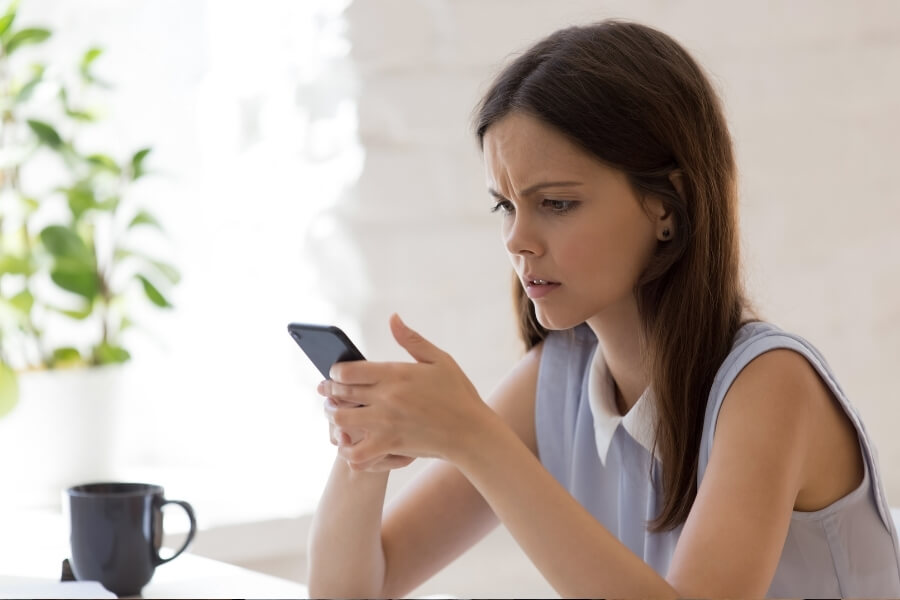 Woman checking her phone for spam risk 